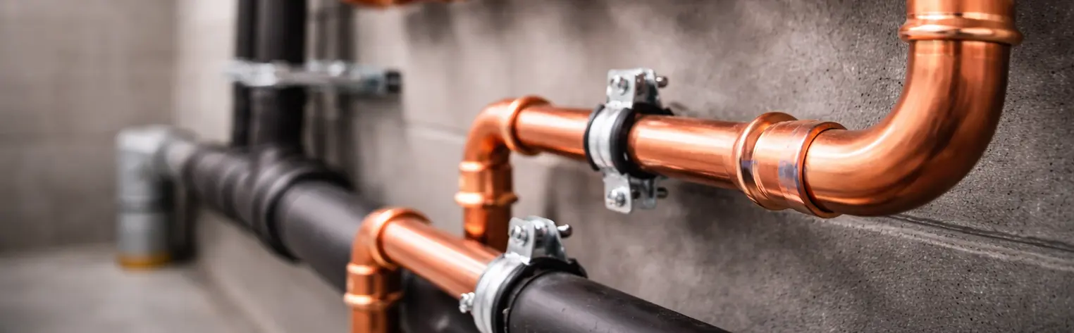 polished copper pipes in industrial setting.webp