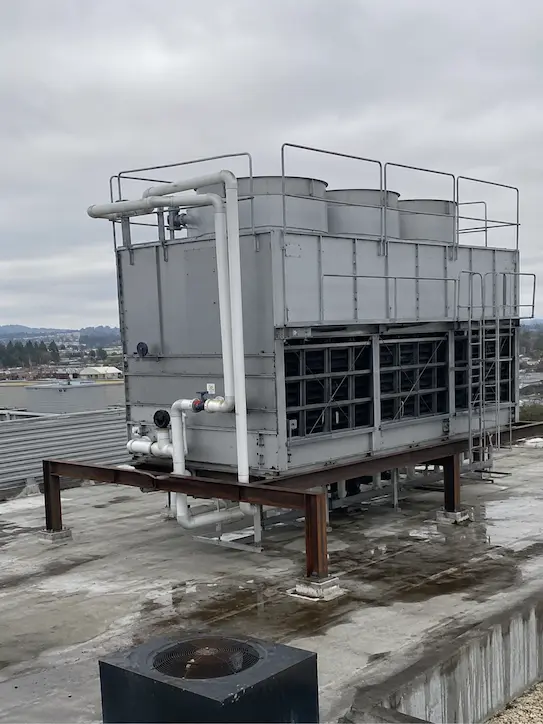 Commercial cooling tower service equipment installed on a wet rooftop in the Pacific Northwest.
